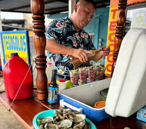 Puesto de tegogolos Pelayo, se encuentra preparando cocteles de tegogolos