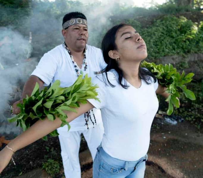 Brujo en Catemaco realizando limpieza energética con plantas a mujer