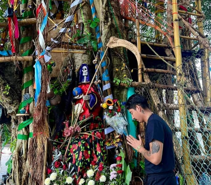 brujo unicornio negro haciendo reverencia a una escultura en referencia a la santa muerte