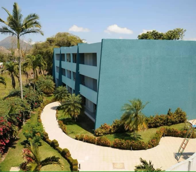 Foto del edificio del hotel en color verde con tres plantas