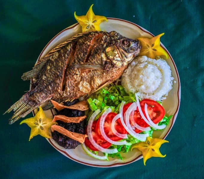 mojarra frita con rodajas de tomate y cebolla. Comida típica en Catemaco